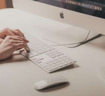 person typing on Apple keyboard