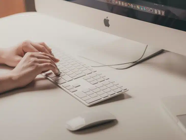 person typing on Apple keyboard
